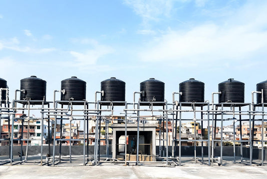 Rooftop overhead water tanks and pipework on an Indian apartment building