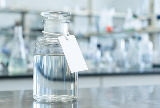 A labelled glass water sample bottle on a laboratory bench ready for testing